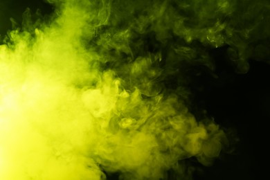 Photo of Hookah smoke in yellow light on black background, closeup