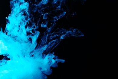 Photo of Hookah smoke in blue light on black background, closeup. Space for text