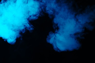 Photo of Hookah smoke in blue light on black background, closeup