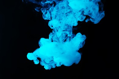 Photo of Hookah smoke in blue light on black background, closeup