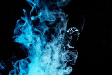 Photo of Hookah smoke in blue light on black background, closeup