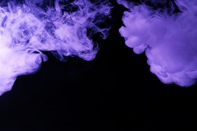 Photo of Hookah smoke in violet light on black background, closeup. Space for text