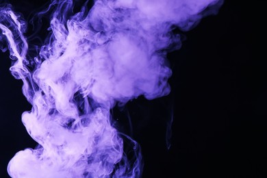 Photo of Hookah smoke in violet light on black background, closeup. Space for text