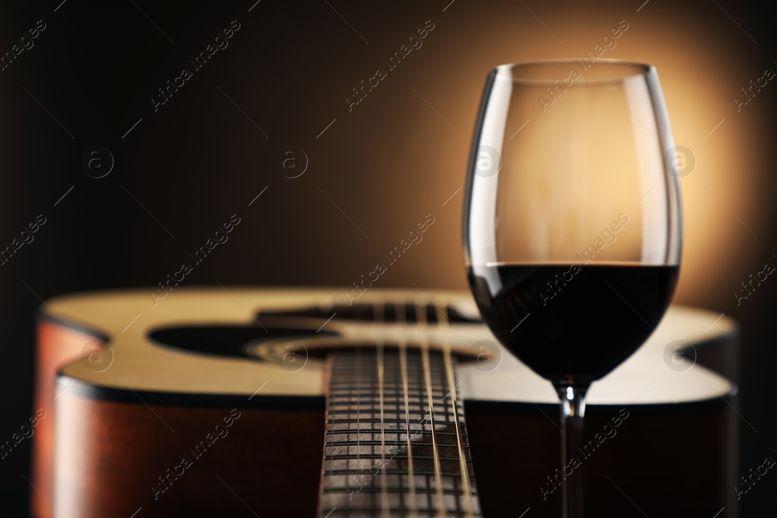 Acoustic guitar and glass of red wine on black background, closeup. Space for text Photo of Acoustic guitar and glass of red wine on black background, closeup. Space for text