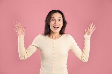 Photo of Portrait of surprised woman on pink background