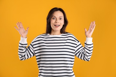 Photo of Portrait of surprised woman on orange background