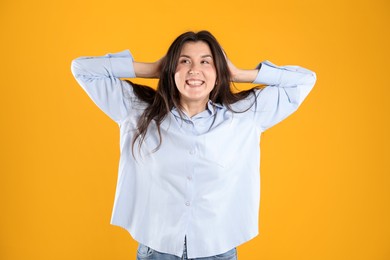 Photo of Portrait of surprised woman on orange background