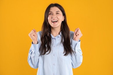 Photo of Portrait of surprised woman on orange background