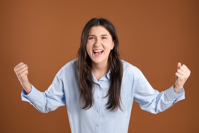 Photo of Portrait of surprised woman on brown background