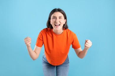Photo of Portrait of emotional woman on light blue background