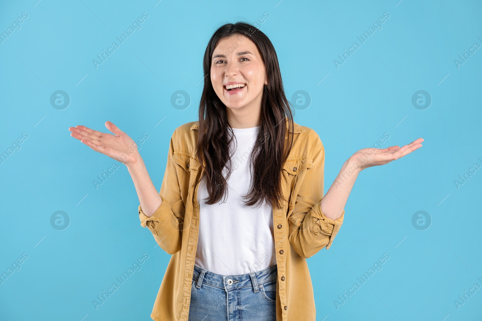 Portrait of surprised woman on light blue background Photo of Portrait of surprised woman on light blue background
