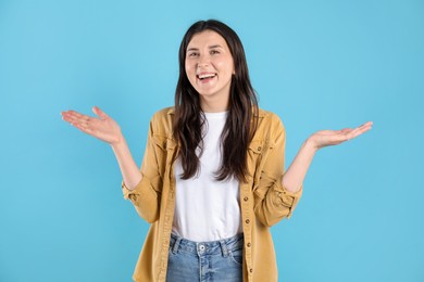 Photo of Portrait of surprised woman on light blue background