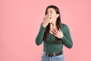 Photo of Portrait of surprised woman on pink background, space for text