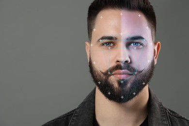 Image of Facial recognition system. Scanning man's face for authentication against grey background