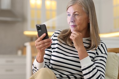 Image of Woman unlocking her smartphone with facial scanner in kitchen. Biometric verification