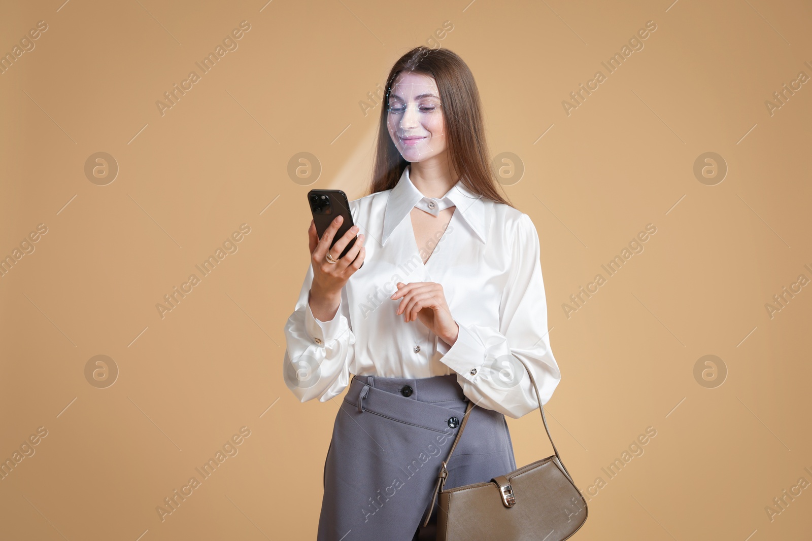 Woman unlocking her smartphone with facial scanner against pale brown background. Biometric verification Image of Woman unlocking her smartphone with facial scanner against pale brown background. Biometric verification