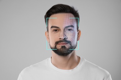 Image of Facial recognition system. Scanning man's face for authentication against light grey background