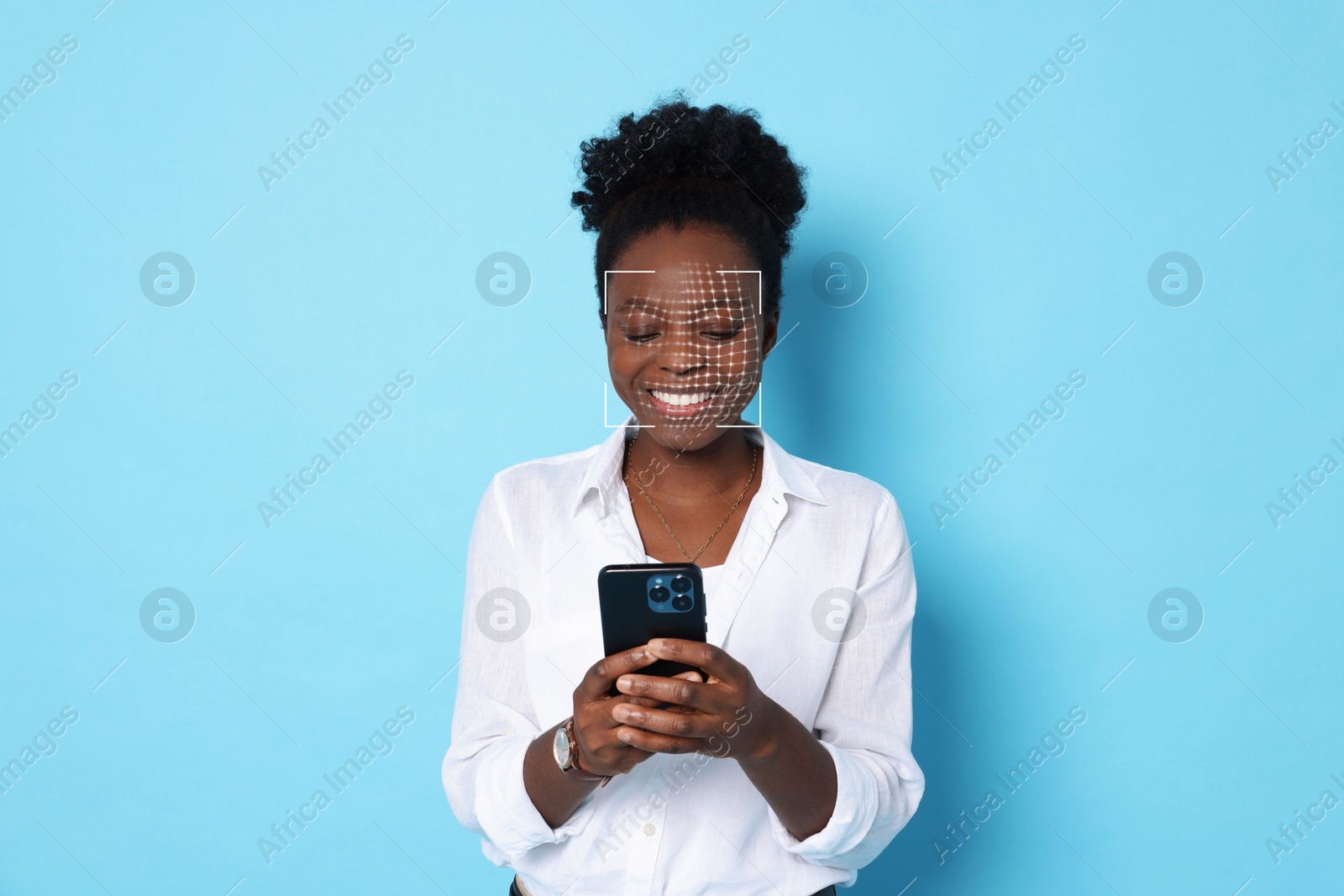 Woman unlocking her smartphone with facial scanner against light blue background. Biometric verification Image of Woman unlocking her smartphone with facial scanner against light blue background. Biometric verification