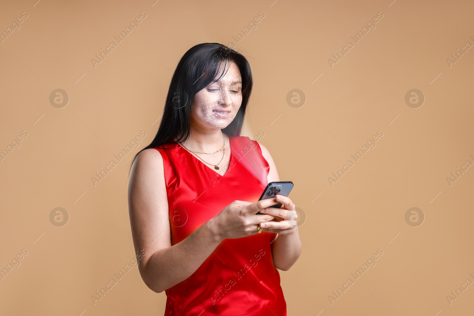 Woman unlocking her smartphone with facial scanner against pale brown background. Biometric verification Image of Woman unlocking her smartphone with facial scanner against pale brown background. Biometric verification