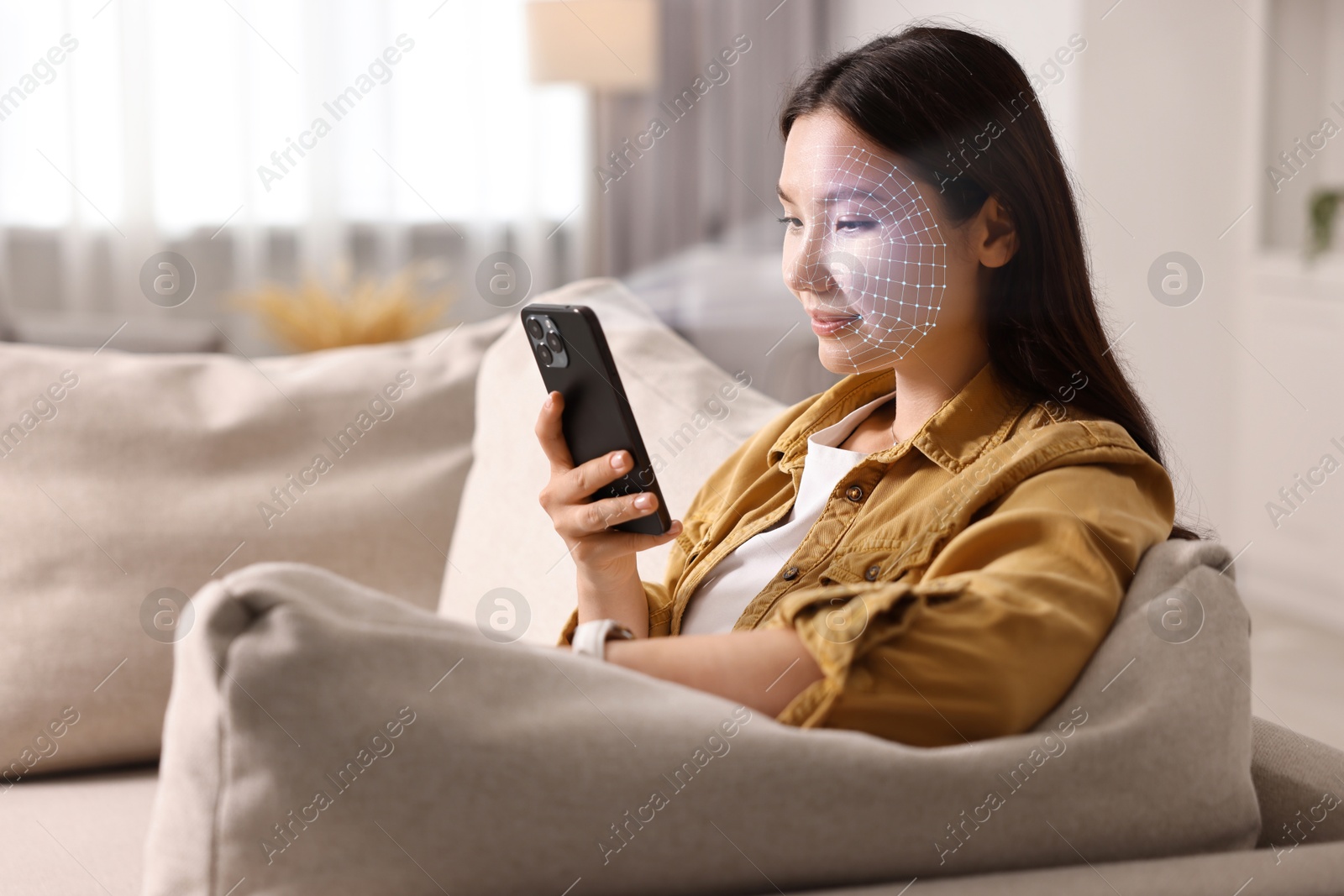 Woman unlocking her smartphone with facial recognition app at home. Biometric verification Image of Woman unlocking her smartphone with facial recognition app at home. Biometric verification