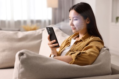 Image of Woman unlocking her smartphone with facial recognition app at home. Biometric verification