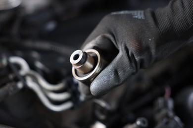Photo of Auto part. Professional mechanic with bearings near open hood of car indoors, closeup. Space for text