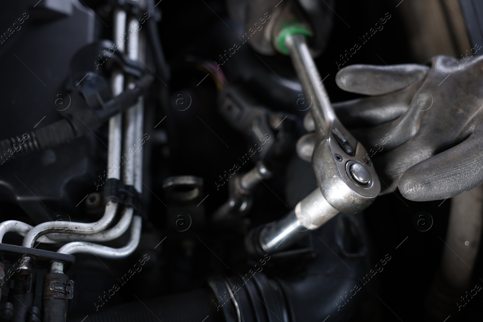 Auto parts. Professional mechanic with torque wrench fixing car indoors, closeup Photo of Auto parts. Professional mechanic with torque wrench fixing car indoors, closeup