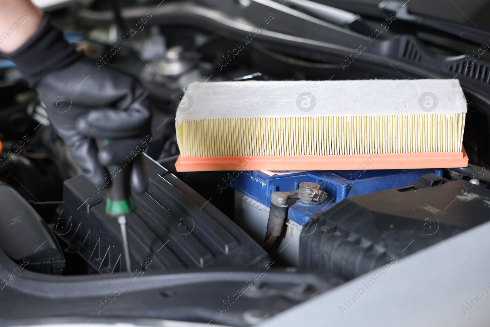 Auto part. Professional mechanic with screwdriver fixing car indoors, focus on air filter Photo of Auto part. Professional mechanic with screwdriver fixing car indoors, focus on air filter