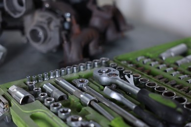 Photo of Different auto parts and tools on table indoors, closeup