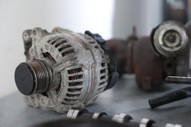 Photo of Different auto parts on grey table indoors, closeup