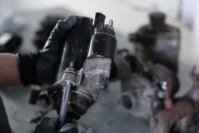 Photo of Auto part. Professional mechanic with starter motor indoors, closeup. Space for text