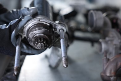 Photo of Auto parts. Professional mechanic with starter motor at table indoors, closeup. Space for text