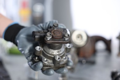 Photo of Auto part. Professional mechanic with power steering pump indoors, closeup. Space for text