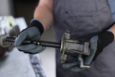 Photo of Auto part. Professional mechanic with manual transmission indoors, closeup