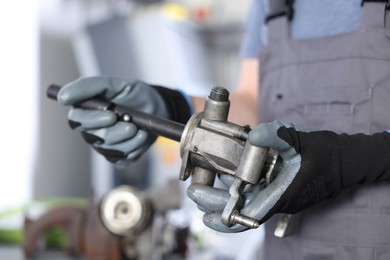Photo of Auto part. Professional mechanic with manual transmission indoors, closeup
