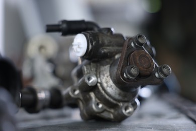 Photo of Auto part. Power steering pump on grey table indoors, closeup