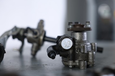 Photo of Different auto parts on grey table indoors, closeup