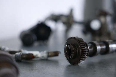 Photo of Different auto parts on grey table indoors, closeup