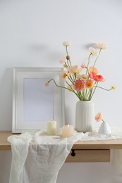 Photo of Bouquet of beautiful poppy flowers, frame and burning candles on table indoors