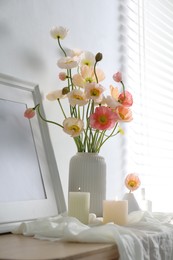 Photo of Bouquet of beautiful poppy flowers, frame and burning candles on table indoors