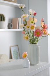 Photo of Beautiful poppy flowers on white table indoors