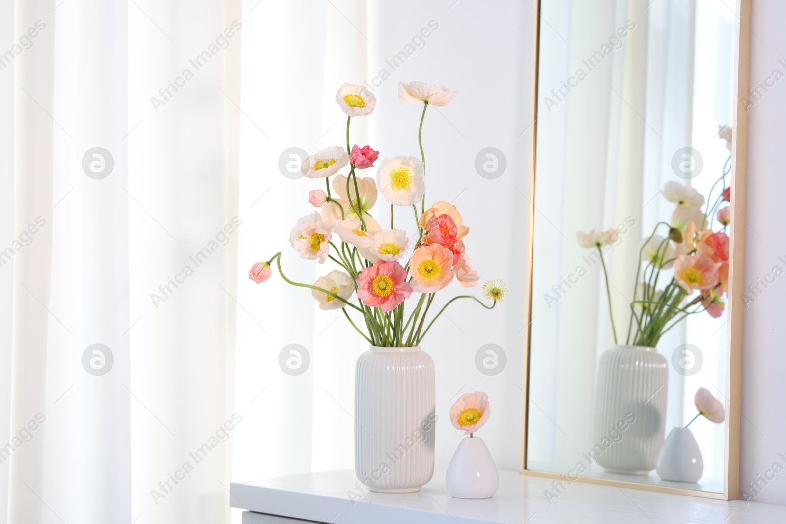 Beautiful poppy flowers and mirror on table indoors Photo of Beautiful poppy flowers and mirror on table indoors