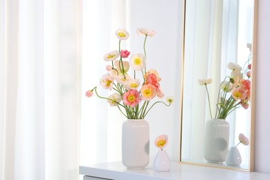 Photo of Beautiful poppy flowers and mirror on table indoors