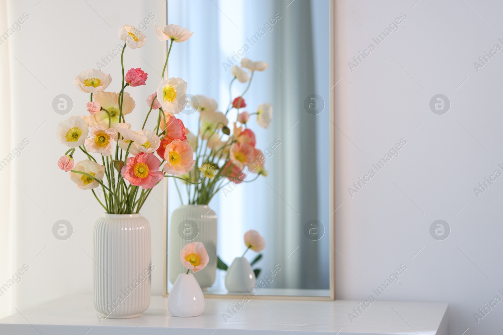 Beautiful poppy flowers and mirror on table indoors. Space for text Photo of Beautiful poppy flowers and mirror on table indoors. Space for text