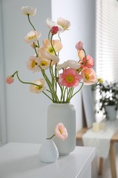 Photo of Beautiful poppy flowers on white table indoors