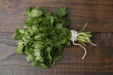 Photo of Bunch of fresh aromatic cilantro on wooden table, top view