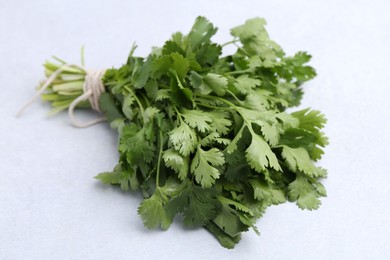 Photo of Bunch of fresh aromatic cilantro on white table, closeup