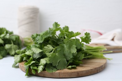Photo of Bunch of fresh aromatic cilantro on white table, closeup