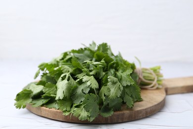 Photo of Fresh aromatic cilantro on white table, closeup