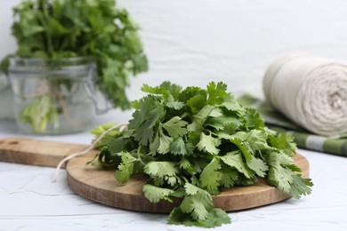 Photo of Fresh aromatic cilantro on white table, closeup